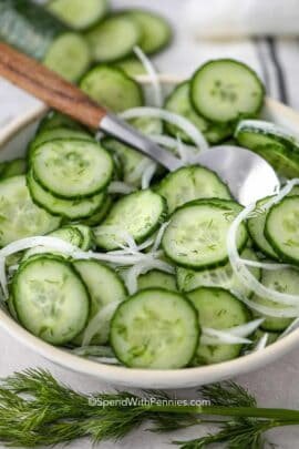 Cucumber Onion Salad in a white bowl with serving spoon