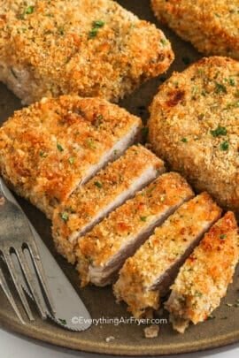 sliced breaded air fryer pork chops on a plate