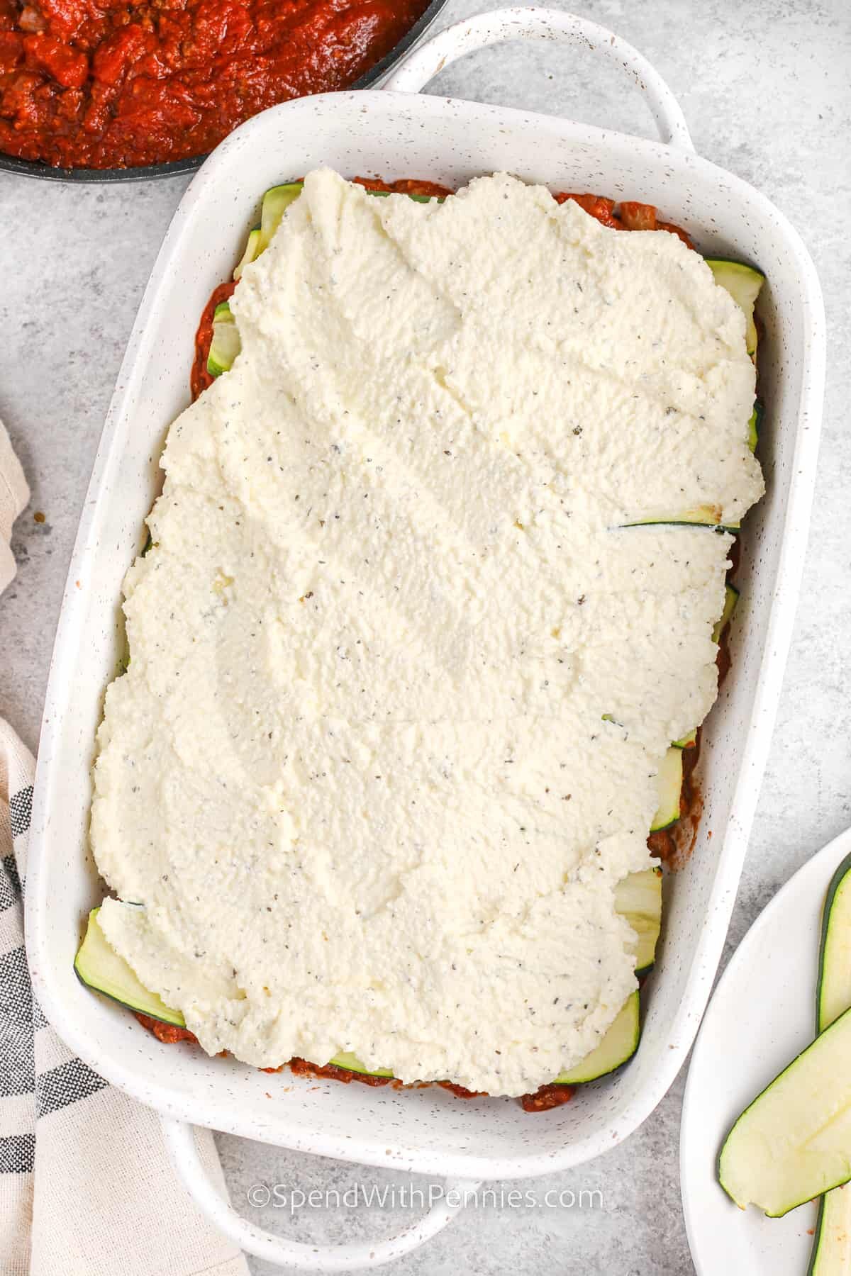 adding zucchini and ricotta layers to dish to make Zucchini Lasagna