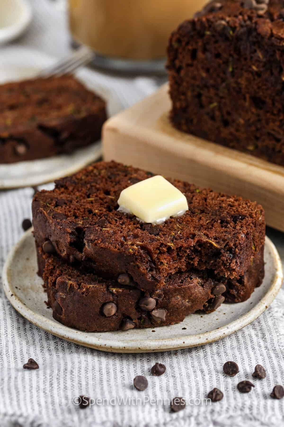 slices of Chocolate Zucchini Bread on a plate with butter on top