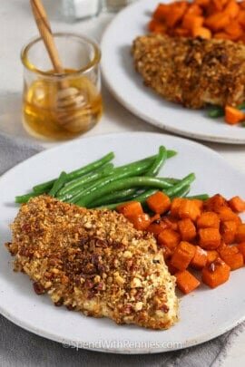 pecan crusted chicken with sweet potatoes and green beans on a plate